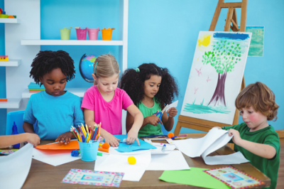 4 kids engaging in art and craft activities around a table