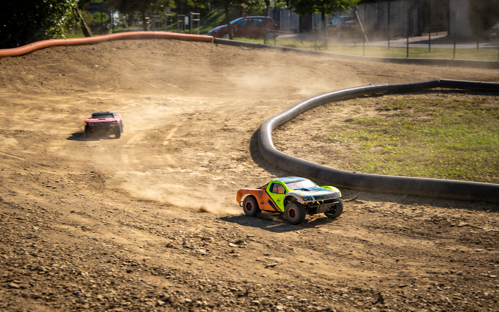 Two offroad RC cars racing on a track