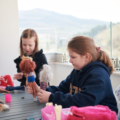 two young girls playing with dolls