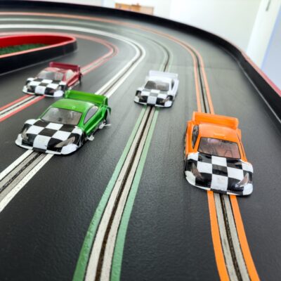 4 slot cars racing towards the viewer