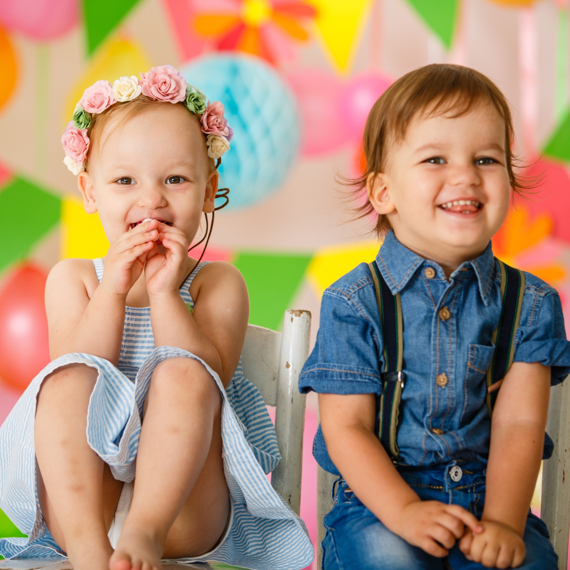 two toddlers smiling and giggling at a party