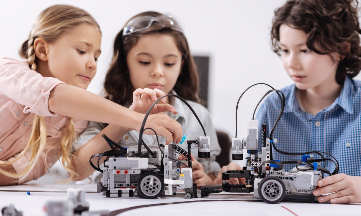 a group of kids playing with robotics toys